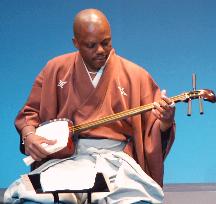 Cameroon's W. Vincent performs samisen as accredited player